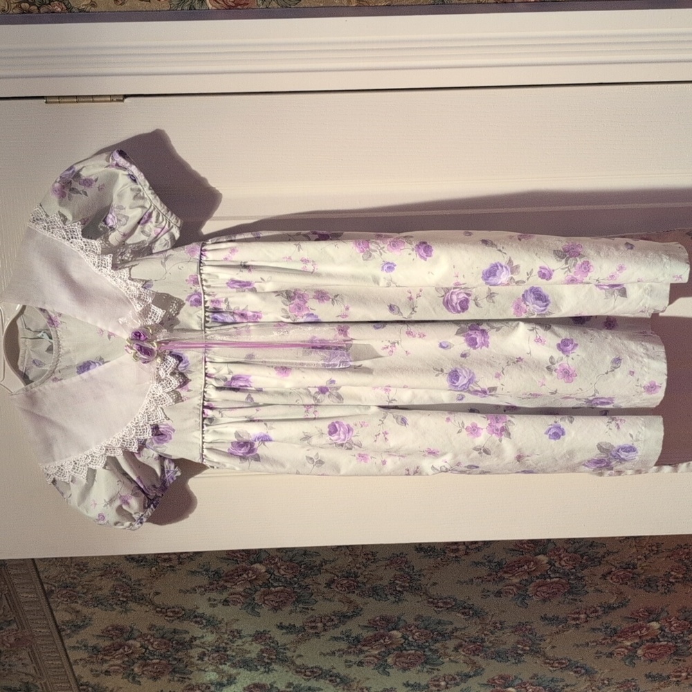A Mint Dress With Purple Flowers And A Squared Collar Overlay With Purple Flower